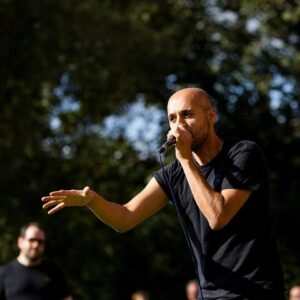Danny Ladwa, founder of School of Beatbox beatboxing on stage Danny Ladwa holding a microphone and beatboxing on stage.